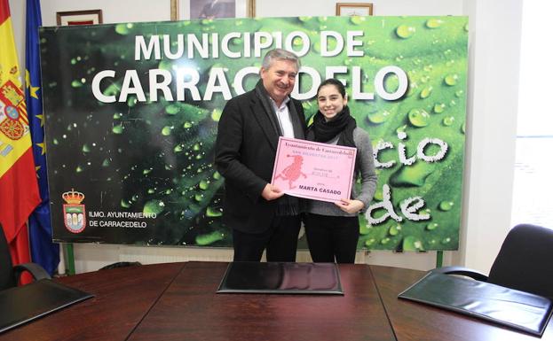 El alcalde de Carracedelo, Raúl Valcarce, entrega el cheque de la San Silvestre a la deportista Marta Casado.