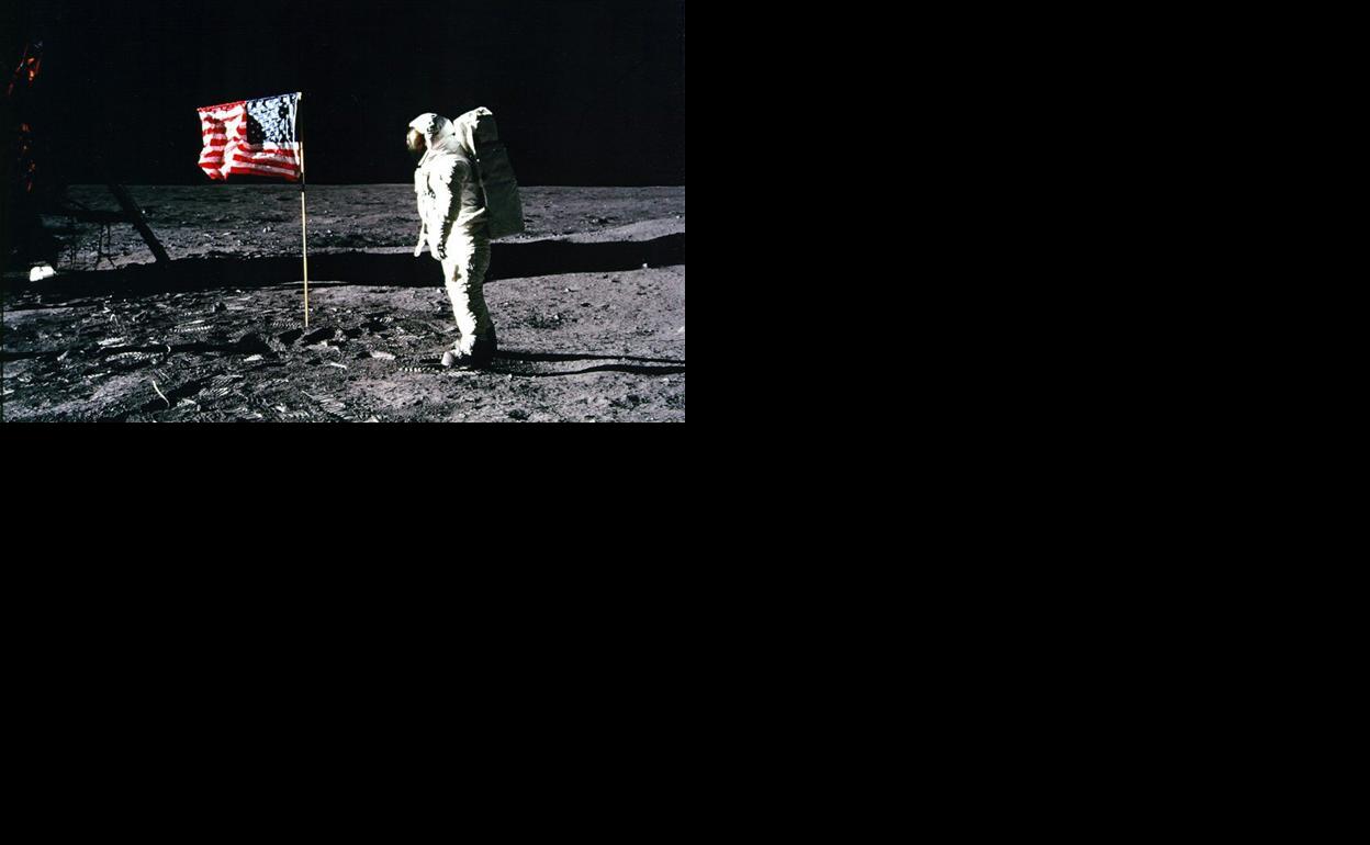 El astronauta Neil Armstrong, junto a una bandera estadounidense, en la superficie lunar.