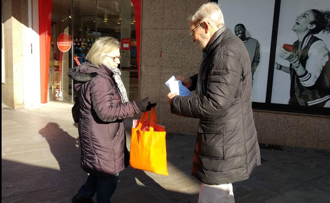 El portavoz municipal del PRB, Tarsicio Carballo (D), reparte octavillas en la plaza de Lazúrtegui.