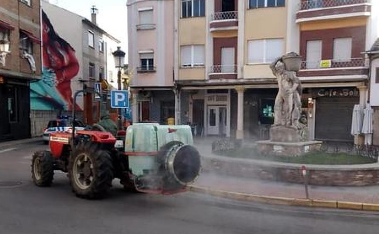 Un agricultor realiza trabajos de fumigación de calles en Cacabelos.