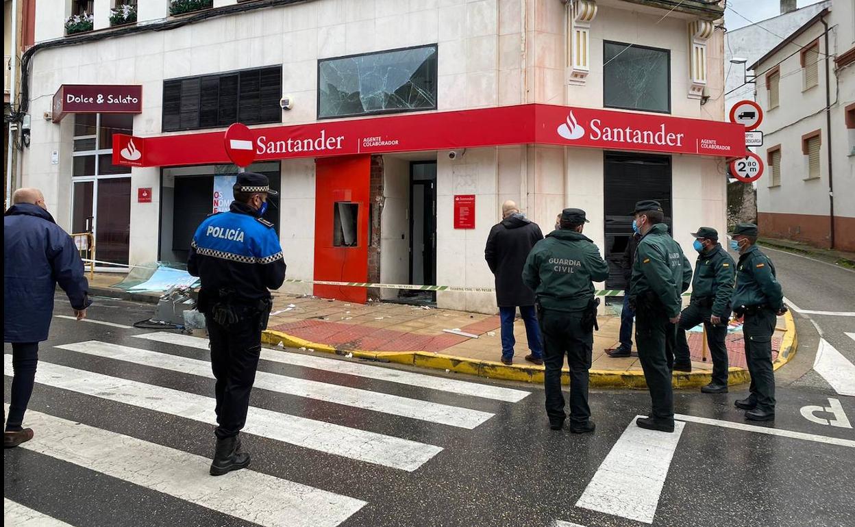 Agentes de la Policía y la Guardia Civil, ante la oficina bancaria donde actuaron los ladrones.