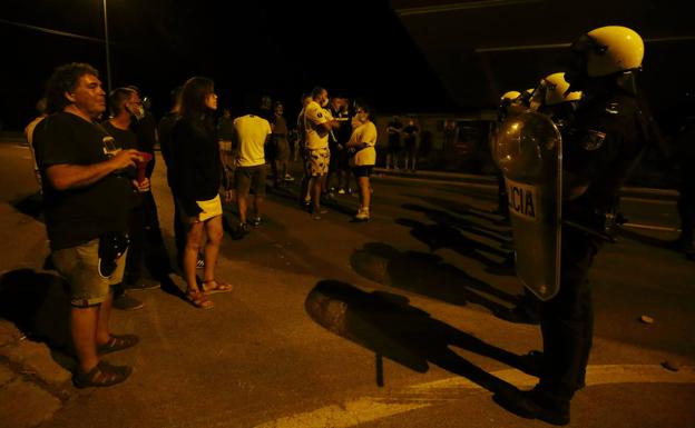 Trabajadores de LM y antidisturbios de la Policía Nacional durante la noche de tensión vivida en agosto.