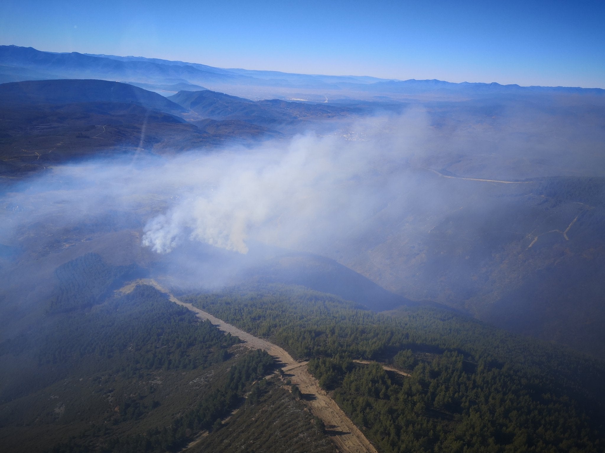 Varios brigadistas y helicópteros trabajan en la extinción de un incendio decretado este martes.