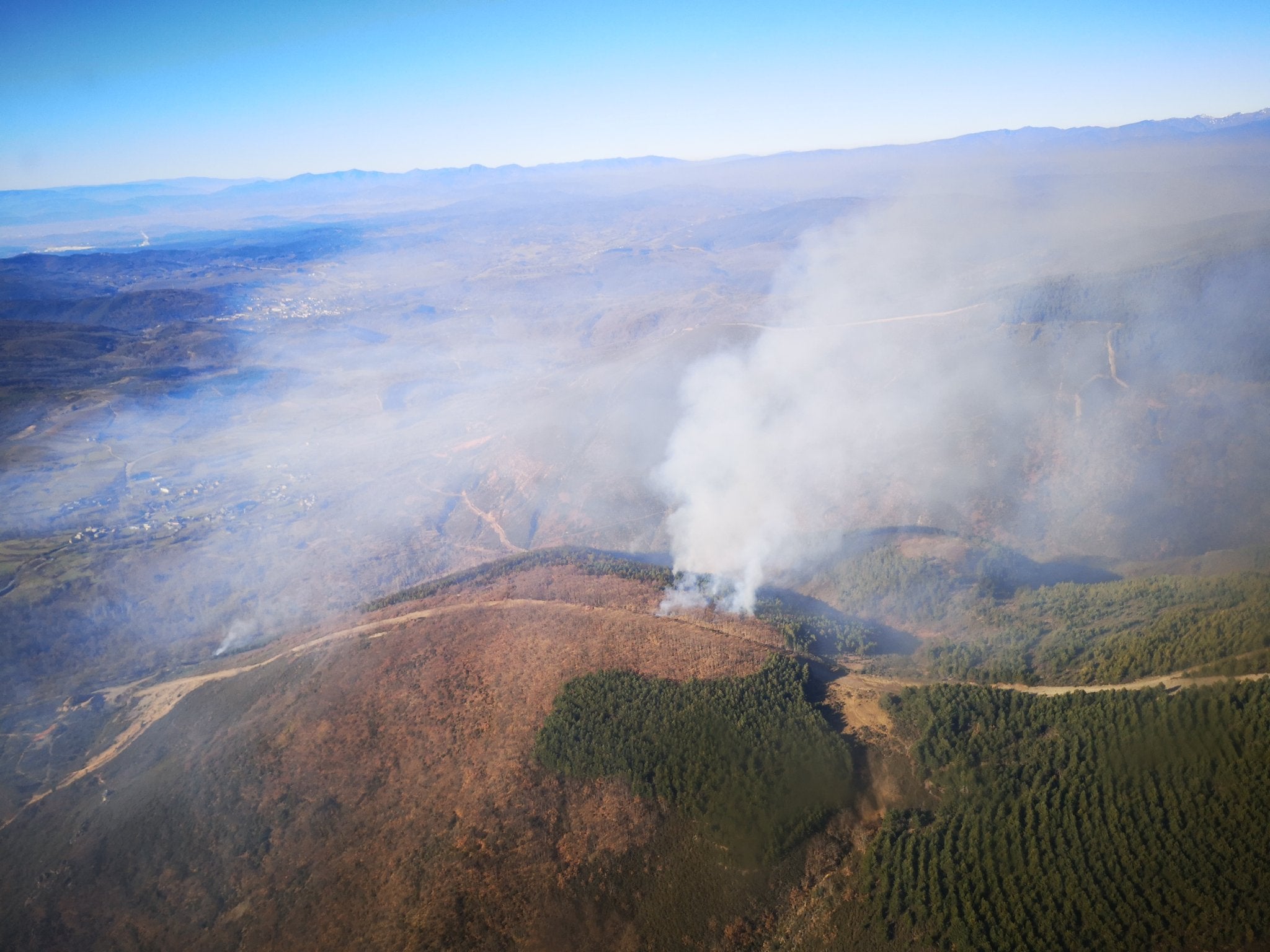 Varios brigadistas y helicópteros trabajan en la extinción de un incendio decretado este martes.