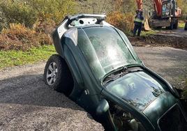 Imagen de uno de los coches que se tragó uno de los socavones abiertos en la carretera LE-4113 que une La Faba con La Cernada.