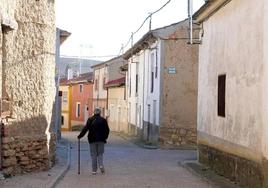 Una mujer camina por un pueblo de Castilla y León.