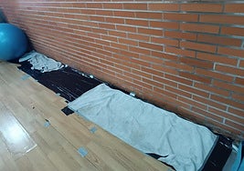 Imagen de la humedad en las paredes y de las toallas y plásticos instaladas en la sala de Pilates del pabellón Ángel Pestaña de Ponferrada.