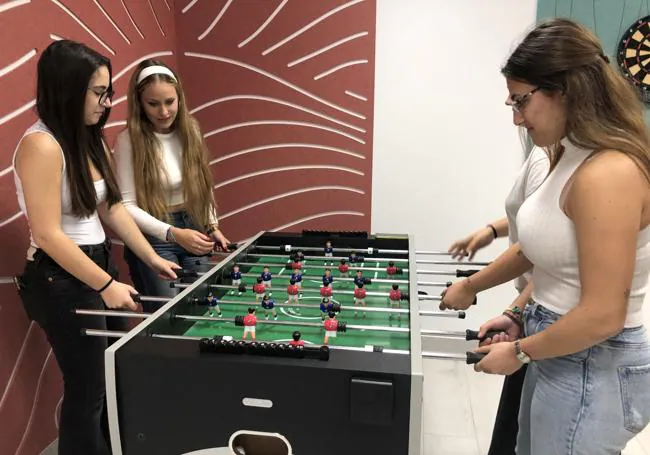 Varias colegiales echan un futbolín en la sala de juegos del Colegio Mayor del Campus de Ponferrada.