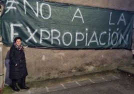 Encarna junto a la pancarta contra la expropiación que ha presidido en los últimos meses la fachada lateral de su vivienda en el barrio de San Andrés.