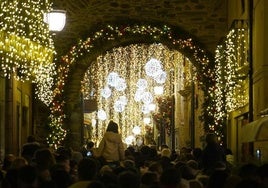 Turistas y visitantes abarrotan la calle del Reloj de Ponferrada para disfrutar de la iluminación navideña.