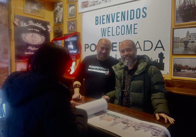 El dibujante César Valle (D) y el propietario de La Destilería, Carlos Rodríguez, en la presentación del skyline en color de Ponferrada.