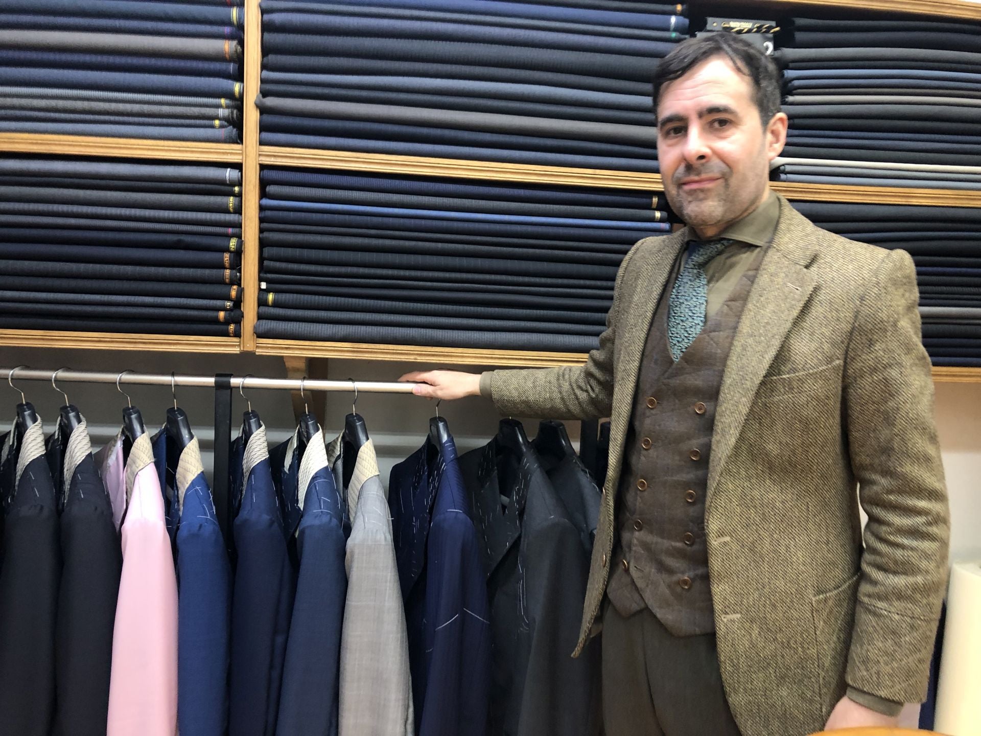 El sastre berciano, entre rollos de telas y chaquetas.
