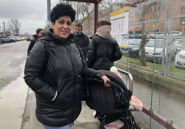 Noelía Uría aguarda junto a su bebé la llegada del autobús tras salir de una consulta en el hospital.
