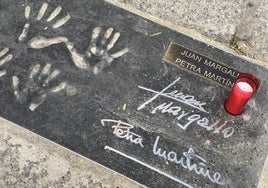Una vela en señal de duelo acompaña este lunes, 3 de marzo, a la placa con la impresión de las manos de Juan Margallo y Petra Martínez.