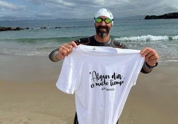 Basurco muestra la camiseta de OncoBierzo en una playa de Tarifa ante el Estrecho de Gibraltar.