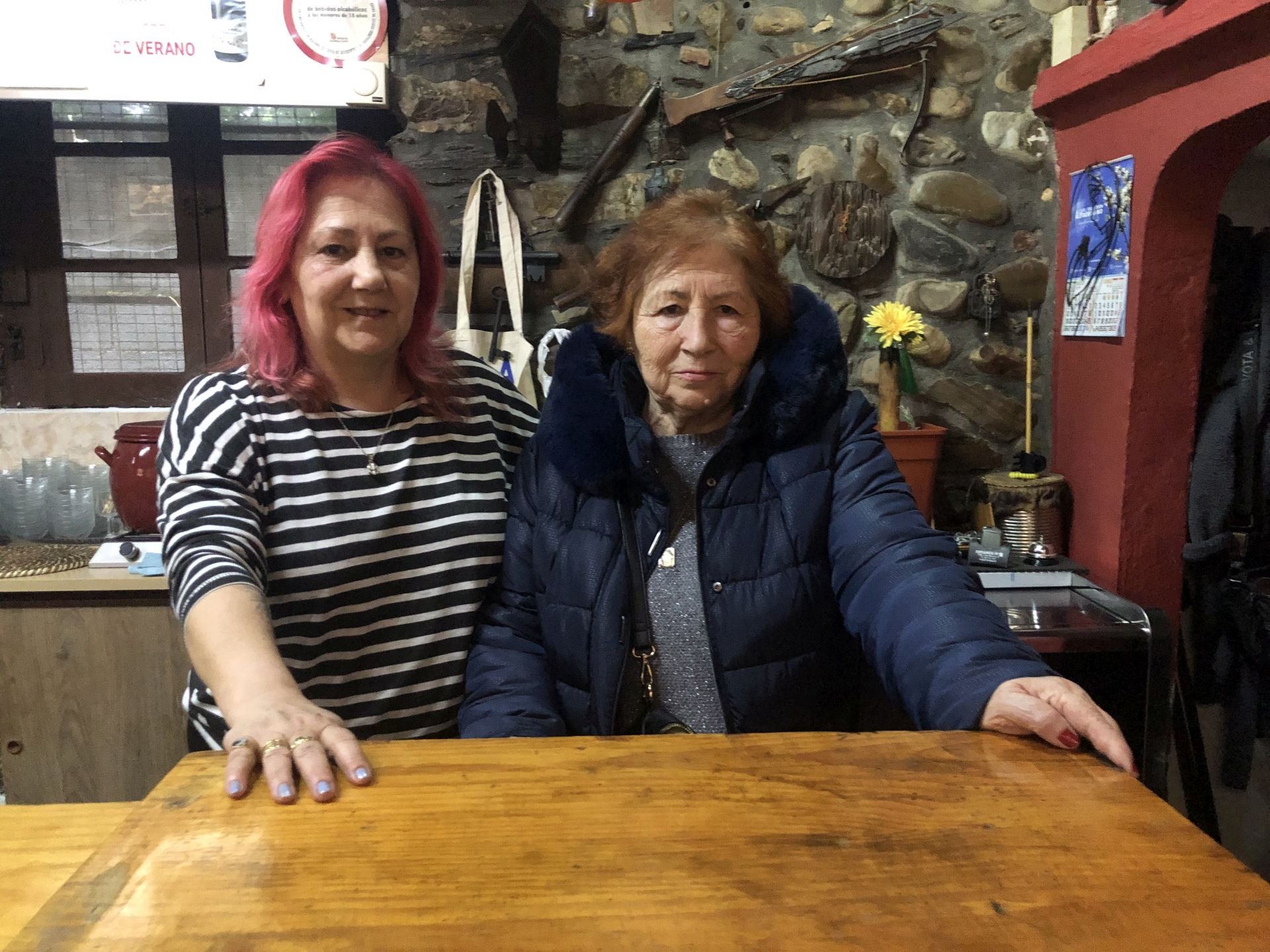 Marina Domínguez (D) y su hija Ana Rodríguez (I), detrás de la barra de la bodega El Pescador de Ponferrada.