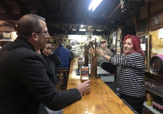 Ana Rodríguez sirve una cerveza a unos clientes en la bodega de El Pescador
