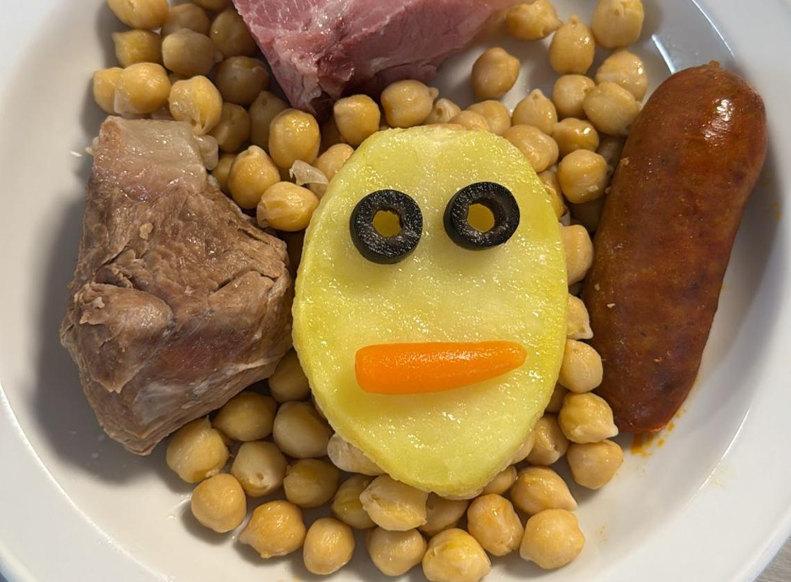 Una cara en una patata adorna un plato de cocido en uno de los menús del servicio de Pediatría del Hospital del Bierzo.