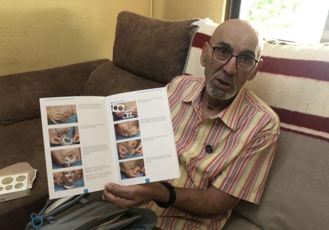 Manuel González enseña la guía que recoge los pasos a seguir para colocarse la bolsa de ostomía.