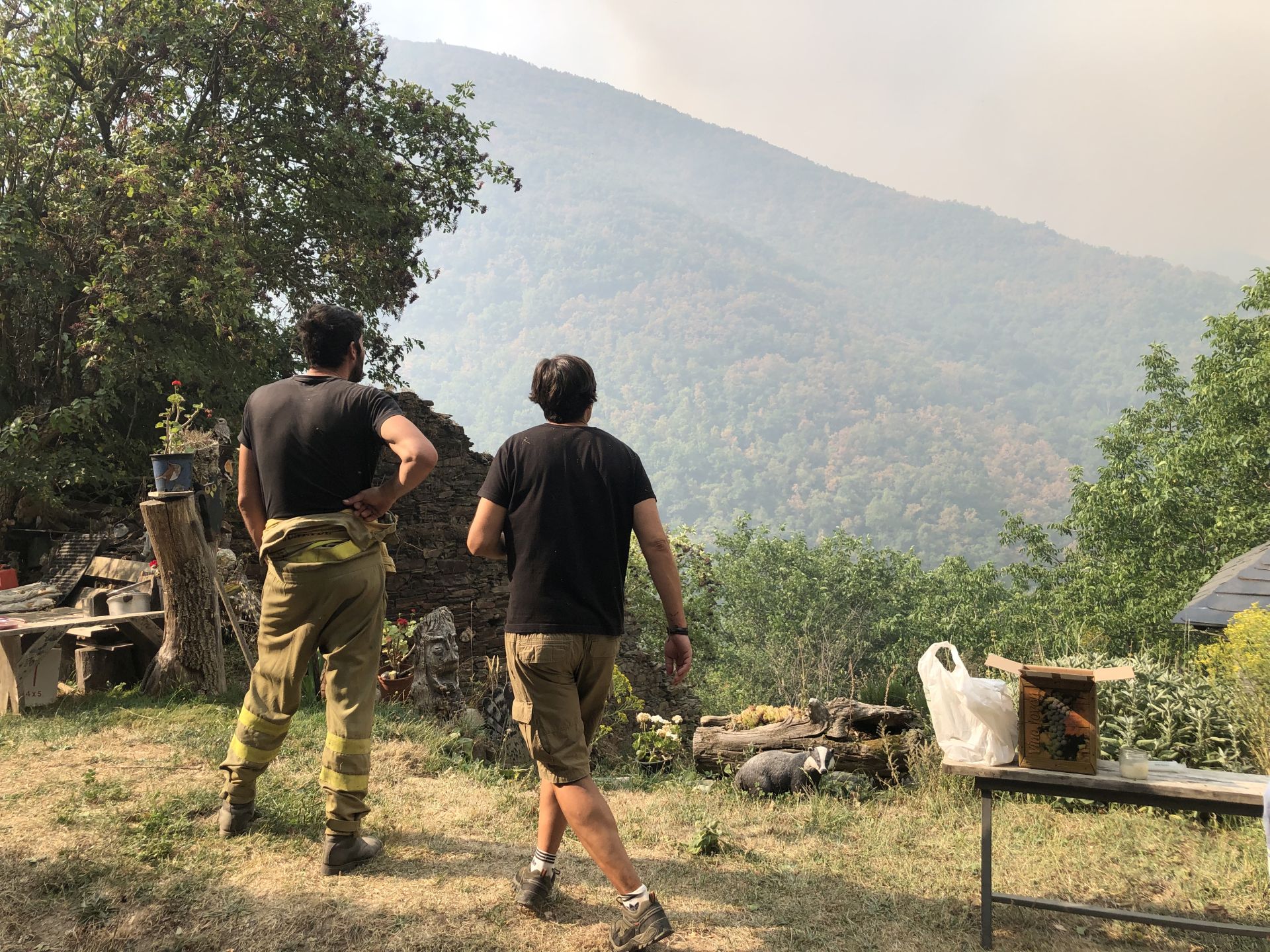 Dos de los habitantes del pueblo contempla la zona por la que amenaza con extenderse el fuego de Yeres.