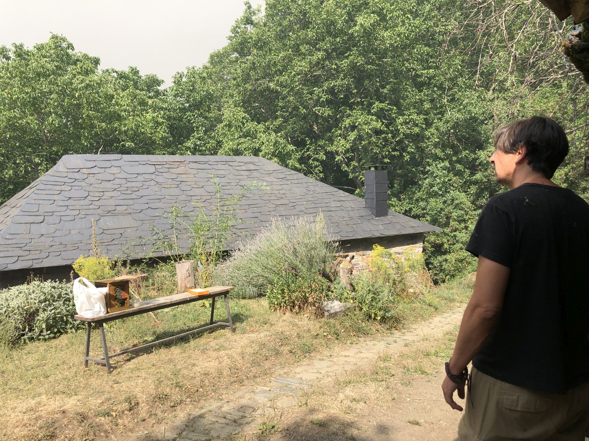 Un vecino de Palacios de Compludo contempla desde el pueblo la gran nube de humo procedente del fuego desatado hace una semana en Yeres.