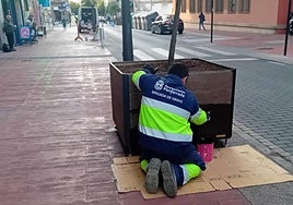 Un operario de la brigada de obras de Ponferrada barniza un macetero en la calle Gómez Núñez.