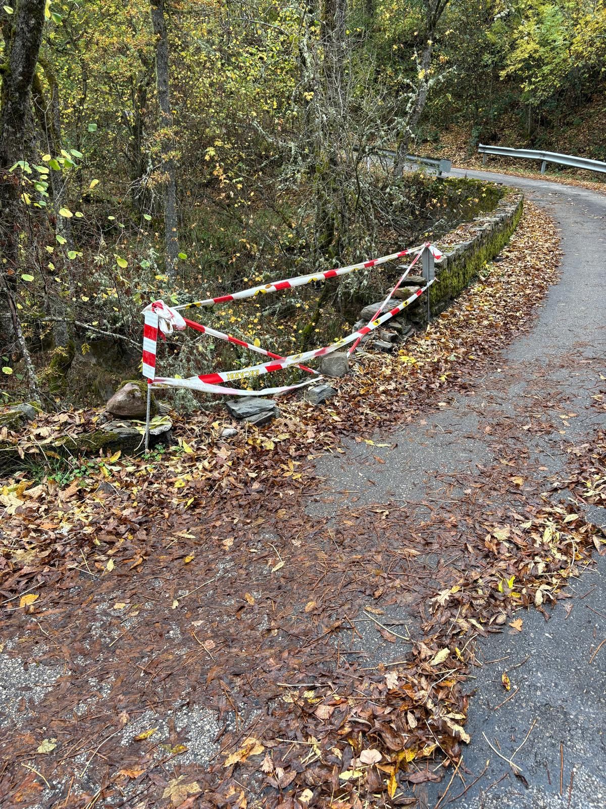 Imagen del petril roto con un cordón de seguridad en la curva del Puente del Jarote, en Salientes (Palacios del Sil).