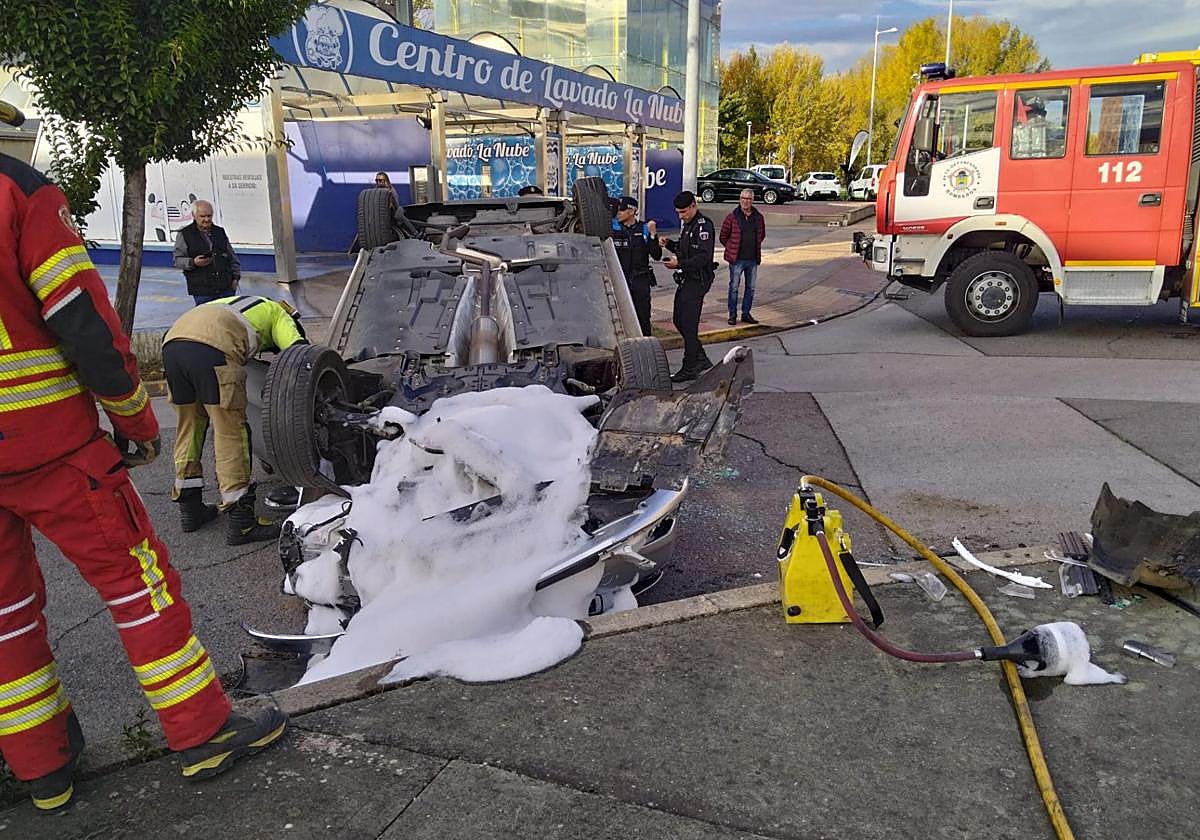 Imagen de los bomberos limpiando la calzada en el lugar del accidente.