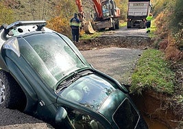 El coche de Fernando Fernández engullido por uno de los socavones que se abrieron en la carretera LE-41013 que une las localidades de La Cernada con La Faba..
