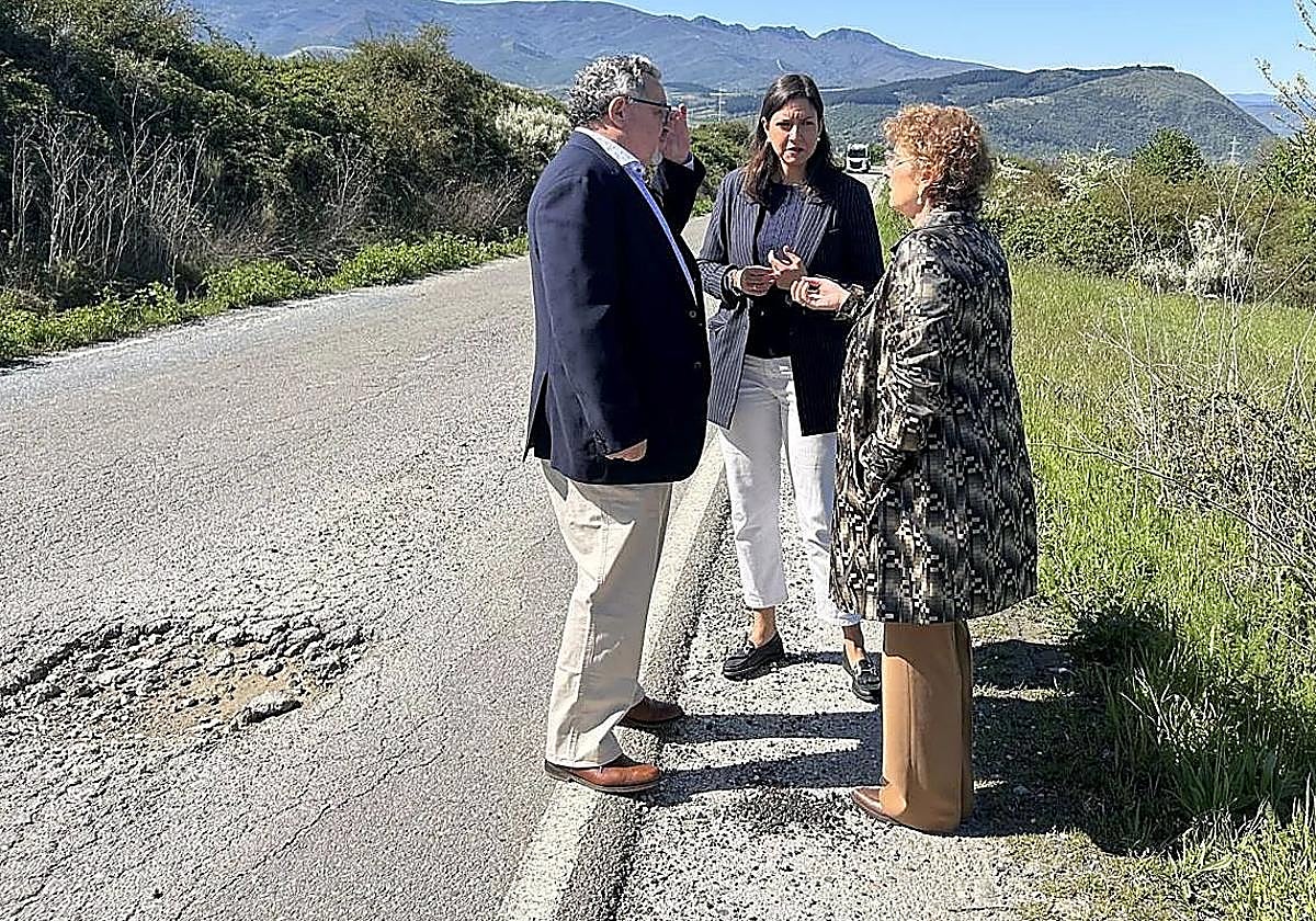La concejala de Fomento (C) y el pedáneo de Santo Tomás de la Ollas (I) conversan con una técnico municipal junto a la carretera de acceso a La Llanada.