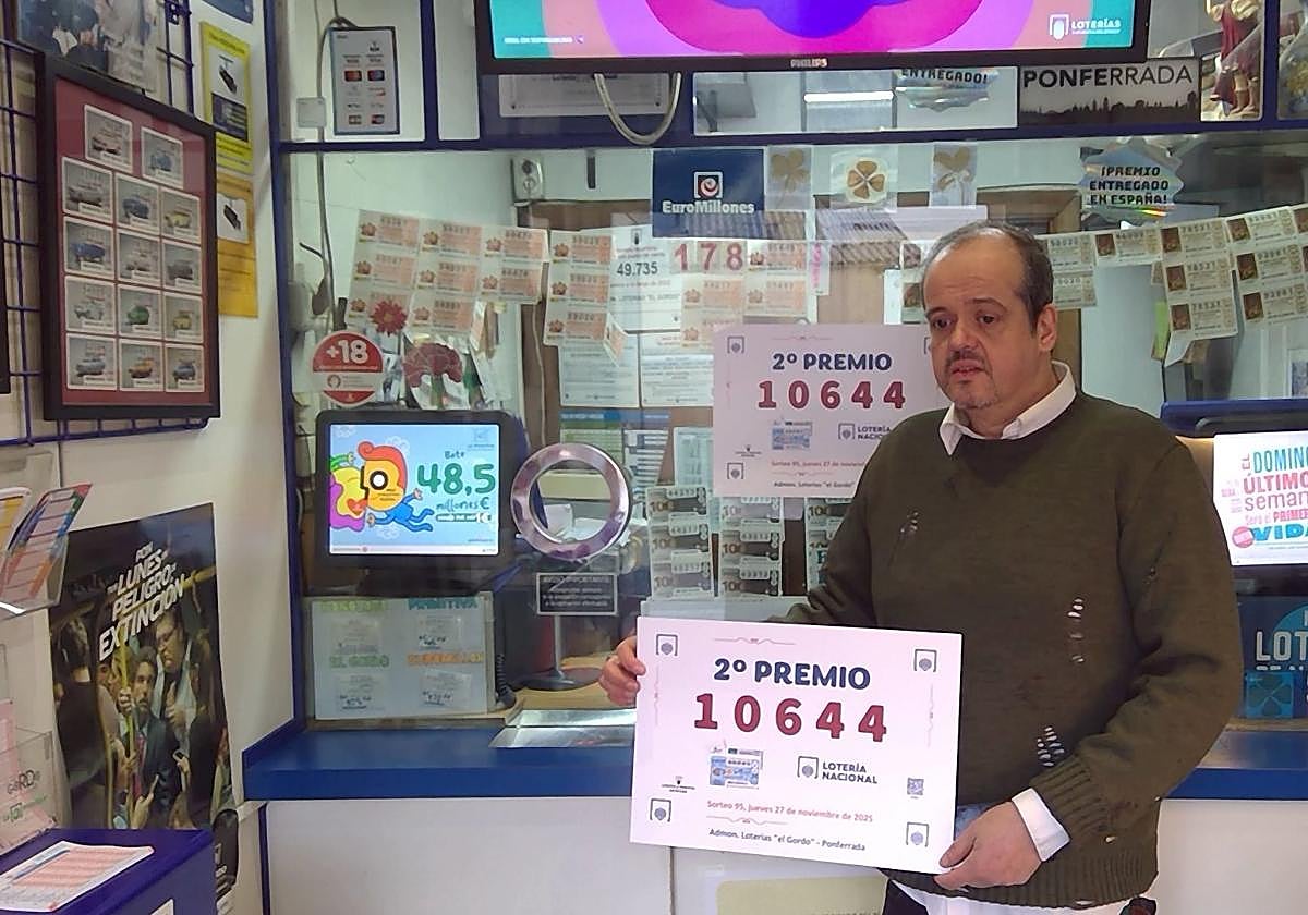 Jose Luis Salas muestra el cartel con el número premiado en la administración de loterías número 1 de Ponferrada.