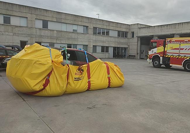 El coche incendiado dentro de la lona en la que permanecerá durante 48 horas.