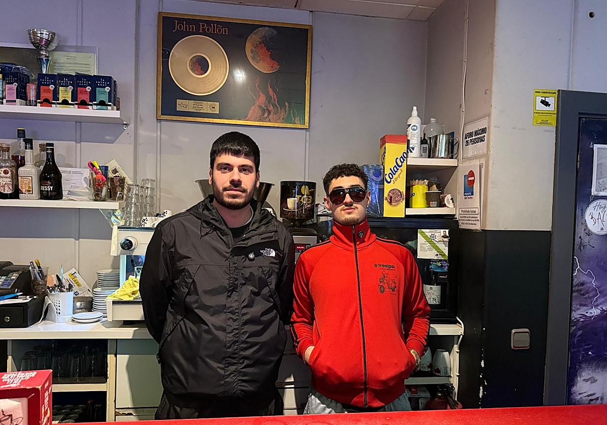Rubén Movilla y César Yebra, en el bar 'London' en Cacabelos junto al disco de oro del cacabelense 'John Pollõn'.