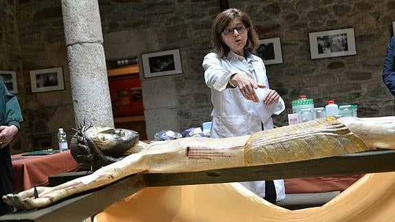 La restauradora Coral Llorca muestra el trabajo de restauración del Cristo de Villanueva.