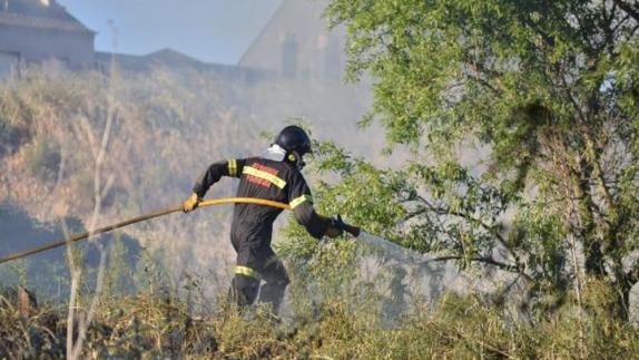 Un bomberos realiza tareas de extinción en un incendio en Ponferrada.