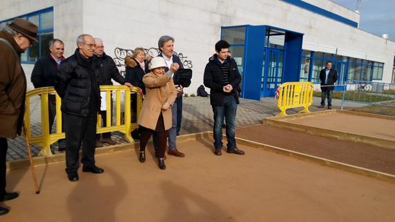 La presidenta de la junta directiva del Centro de Día de Flores del Sil lanza una bola en la inauguración de las tres pistas de petanca.