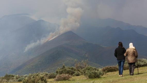 Dos personas contemplan el fuego de Bouzas.