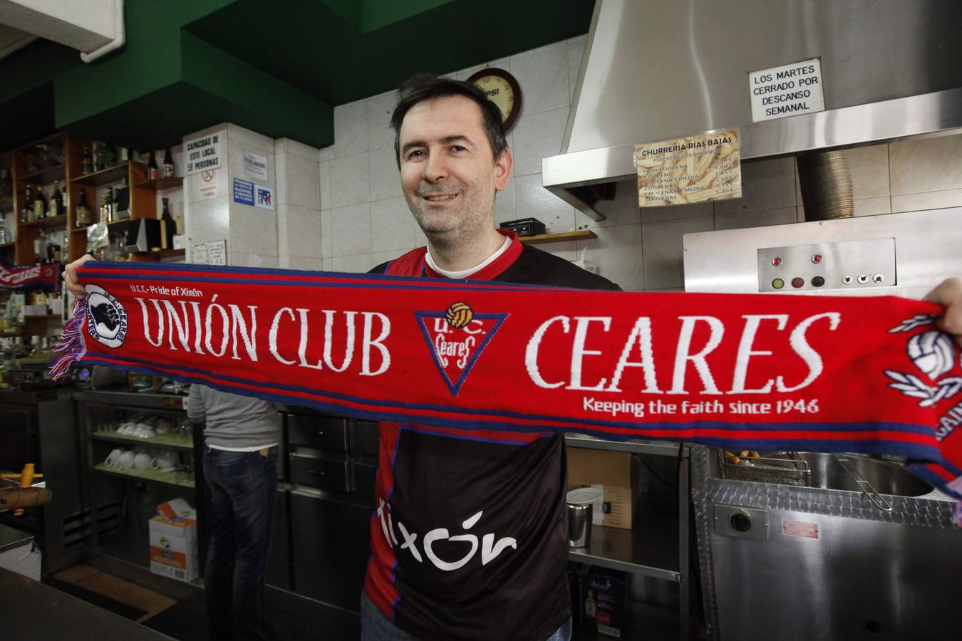 Pablo Carrera, en su bar, con la bandera del Ceares.. 