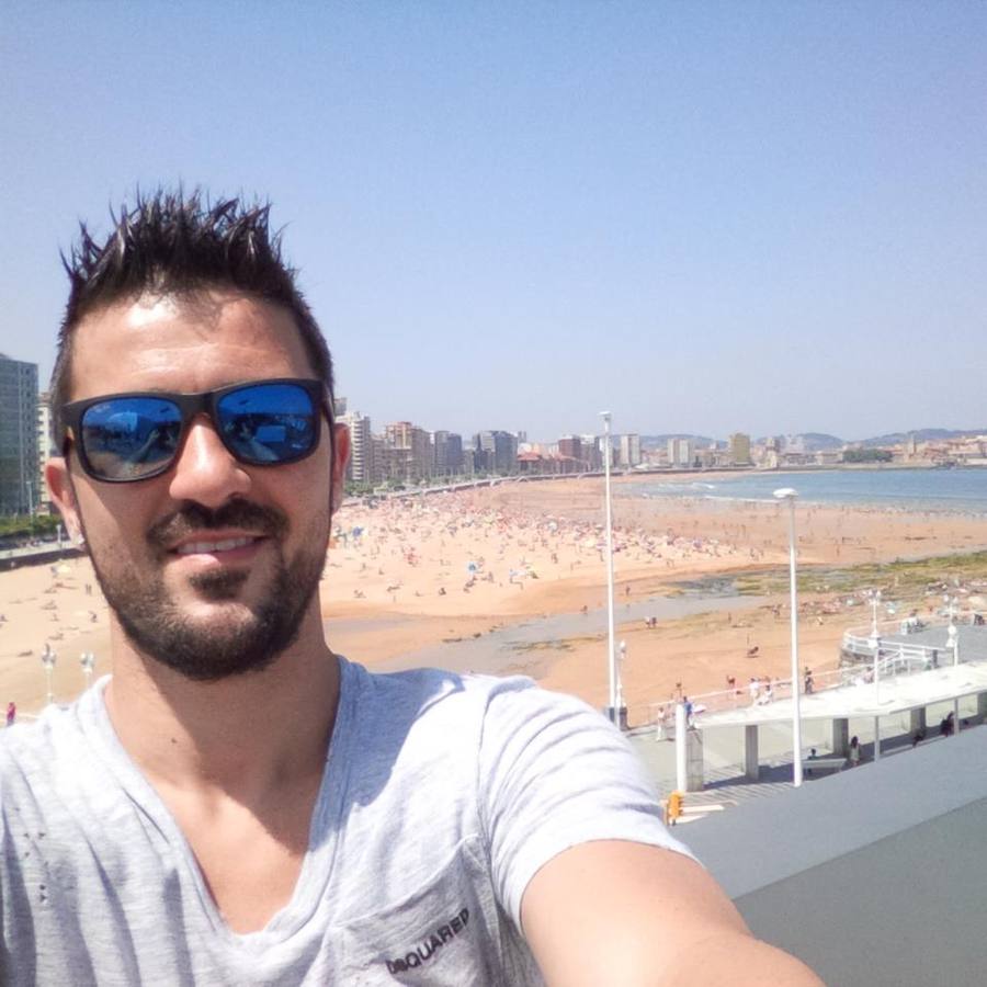 El futbolista asturiano David Villa se saca una 'selfie' con la playa gijonesa de San Lorenzo de fondo