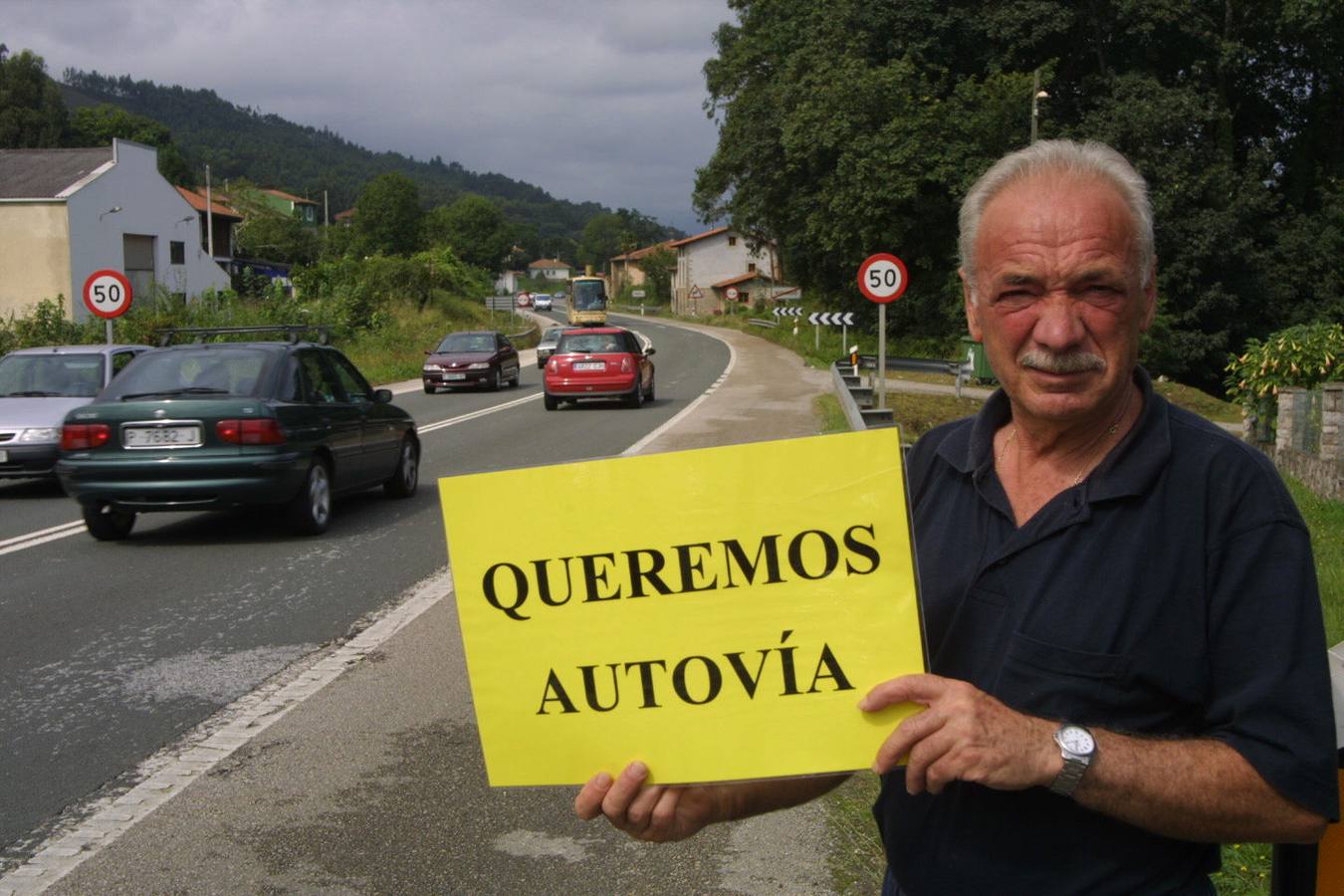 Vecinos del tramo de la carretera N-634 entre Unquera y Llanes reclaman con carteles el inicio de las obras de la autovía del Cantábrico en 2003.