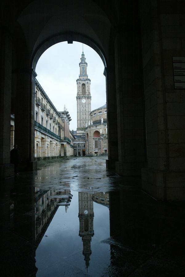 La torre de la Universidad Laboral de Gijón reflejada en un charco de agua de la entrada principal. 02/12/2002