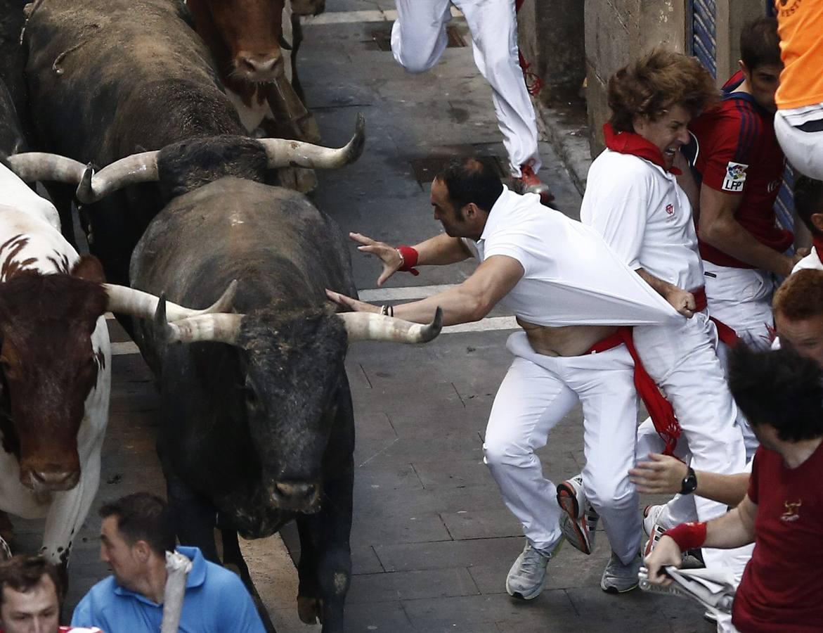 Un mozo intenta enfrentarse a uno de los toros.