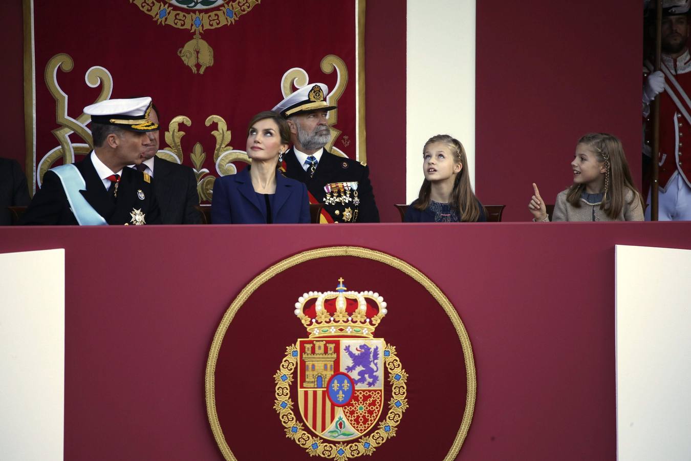 El Rey hace un comentario a sus hijas, Leonor y Sofía, durante el desfile.