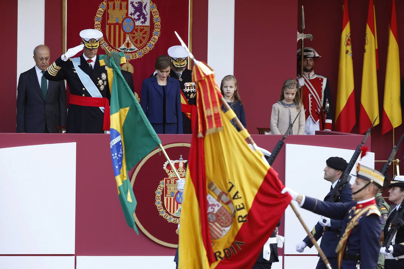 Los Reyes bajan la cabeza al paso de la bandera española.