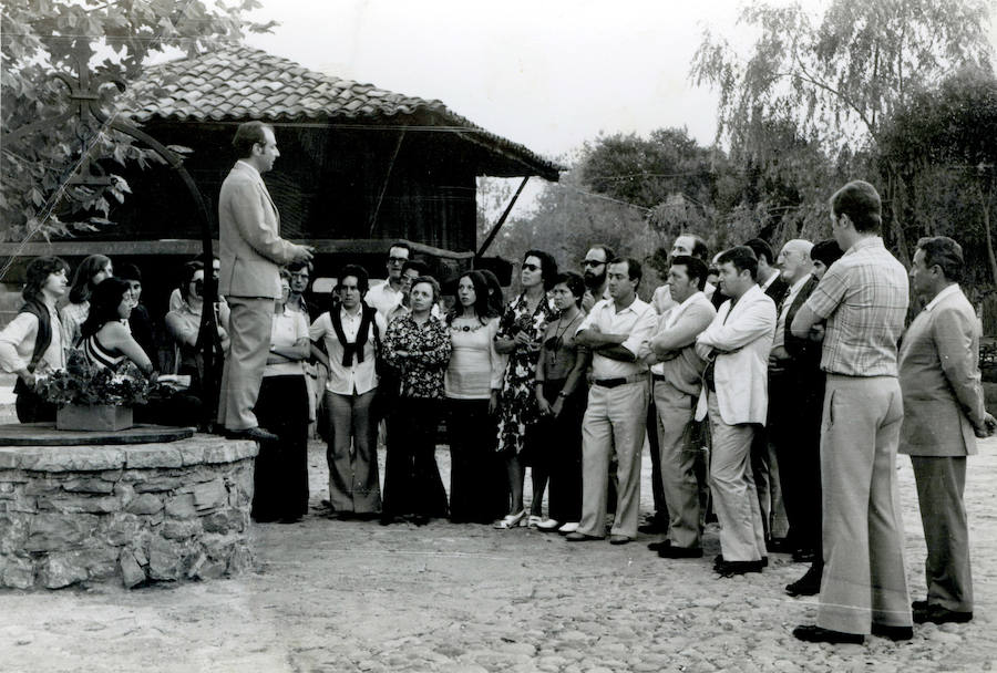 1975. Luis Argüelles Sánchez aparece subido al brocal de un pozo, junto a un hórreo, dando explicaciones a un grupo de visitantes al museo.