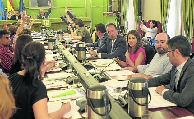 Los representantes del gobierno local con la mano alzada votando la petición del listado de los bienes de la Iglesia.