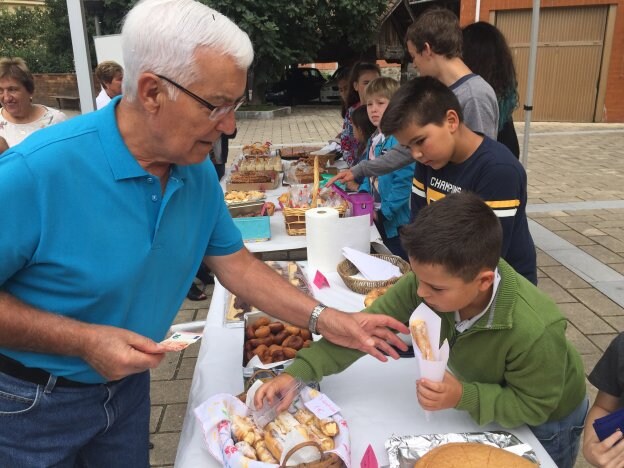 Un vecino compra dulces en uno de los puestos del mercado solidario. 