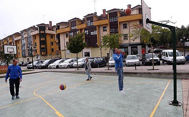 Ganaderos atienden a sus vacas durante la edición del 2016. El alcalde de Nava practica un tiro libre en la canasta. 