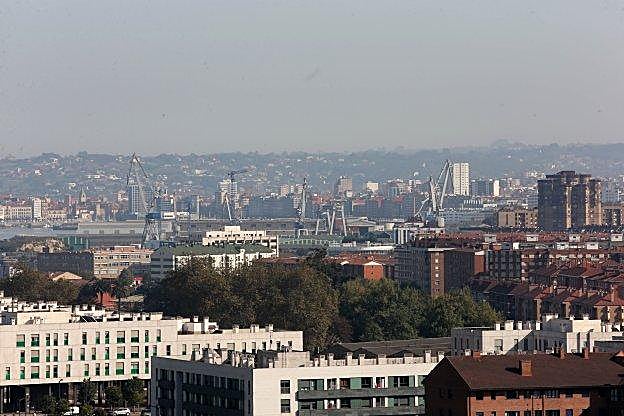 Parque de El Lauredal, rodeado de edificios y con una nube de aire sucio sobre la ciudad. 