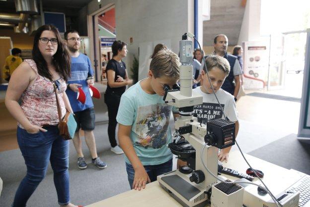 Dos niños, ante un microscopio, en UniOvi. 